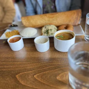 a woman sitting at a table with a plate of food and a glass of water