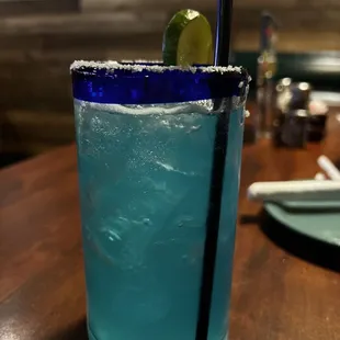 a blue margarita with a lime garnish