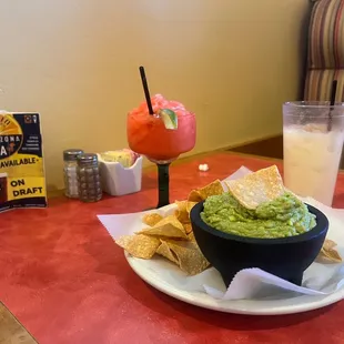 Chips, guacamole, strawberry margarita and a horchata.