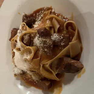 a plate of pasta with meat and gravy