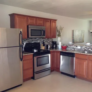 A view of the kitchen, which has been fully renovated to feature new, stainless steel appliances and a washer/dryer.