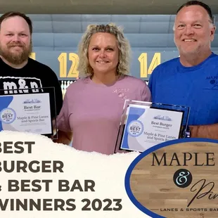 three people holding their awards