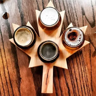 four different beers on a wooden board