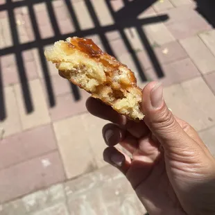 a hand holding a half eaten donut