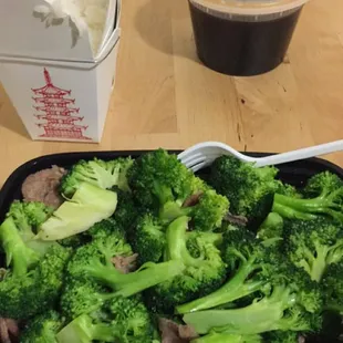 Large beef broccoli with steamed white rice and sauce on the side.