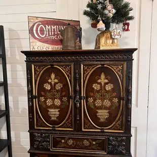 a wooden cabinet with a christmas tree in the background