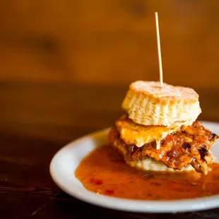The Squawking Goat: Fried chicken, breaded and toasted goat cheese, topped with house made sweet pepper jelly, all on a biscuit sandwich.