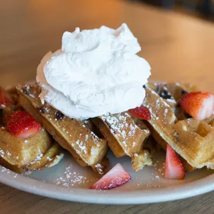 Sweet Grace: Chocolate chip vanilla waffle, topped with strawberries, powdered sugar, whipped cream, served with Bissell Farms maple syrup.