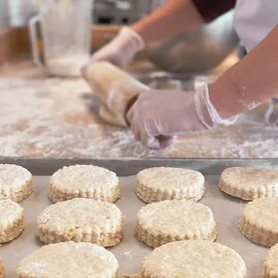 a woman rolling out biscuits