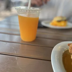 a man sitting at a table with a glass of orange juice