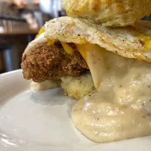 a fried chicken biscuit sandwich with cheese and gravy
