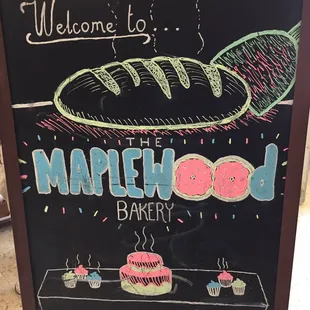 a blackboard with a sign that says welcome to the maplewood bakery