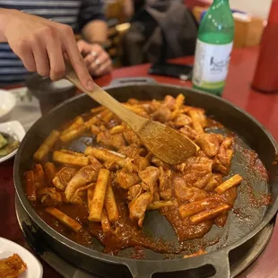 Stirring the chicken, rice cake, and sweet potato