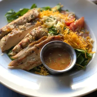 a plate of chicken salad with a side of tortillas