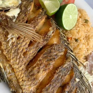 a plate of fish with rice and vegetables