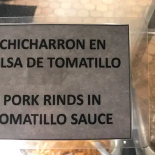 a sign that reads chicharron en salsa de tomatillo pork rings in tomato sauce