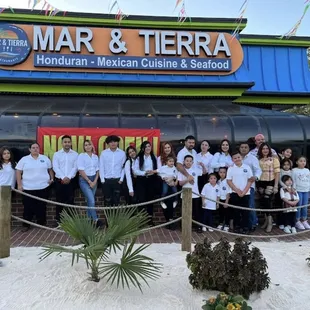 a group of people standing in front of the restaurant