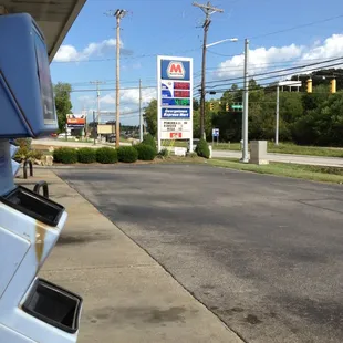 a gas station with a gas station sign in the background