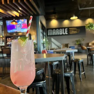 a pink drink with a striped straw