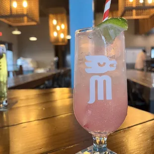 a pink drink with a lime garnish