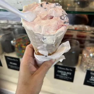 a hand holding a cone of ice cream