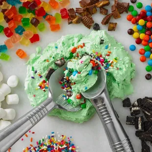 a scoop of green frosting surrounded by assorted candy and candies