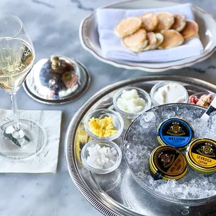 a tray of cavia and a glass of wine