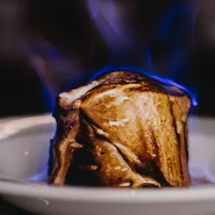 a piece of toast on a plate with blue flames