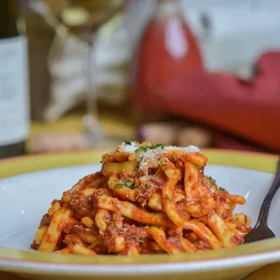 a plate of pasta and a bottle of wine