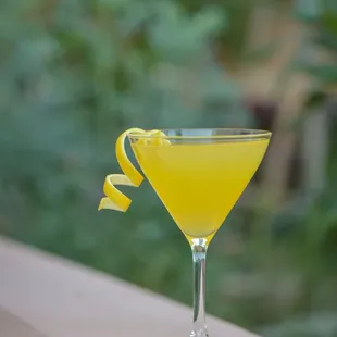 a yellow cocktail in a coupe glass