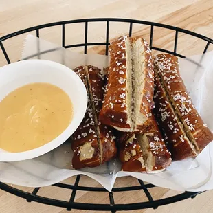 a basket of pretzels and a bowl of mustard