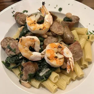 Pasta and Italian Sausage with spinach and grilled shrimp in white wine butter sauce.