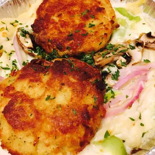 two crab cakes on a bed of noodles