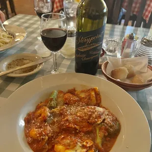a plate of pasta and a bottle of wine