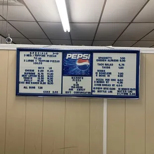 Menu on wall behind cash register - they do take credit/debit cards