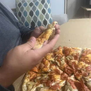 a person holding a slice of pizza