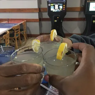 two people holding glasses of lemonade