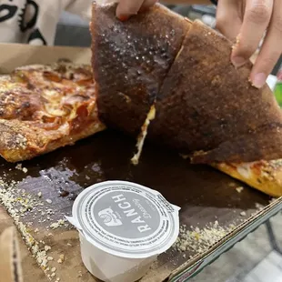 a person taking a slice of pizza