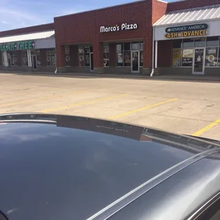 a car parked in front of a pizza place