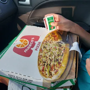 a person holding a box of pizza