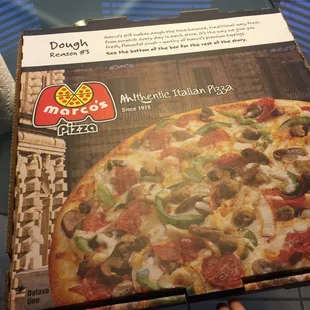 a person holding a box of pizza