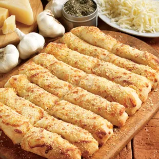 a wooden cutting board with cheese and garlic