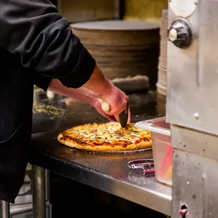  a man cutting a pizza