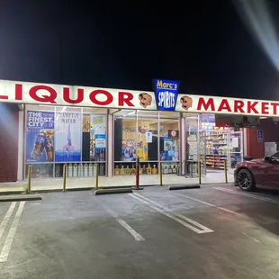 a car parked in front of a liquor market