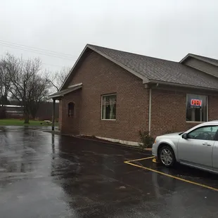 a silver car parked in front of a brick building
