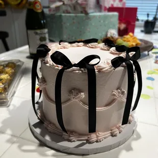 a pink cake with black bows