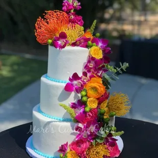 3 tier wedding cake  with buttercream and fresh flowers.   Serves 75