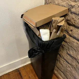 Overflowing trash, cans in the dining room.