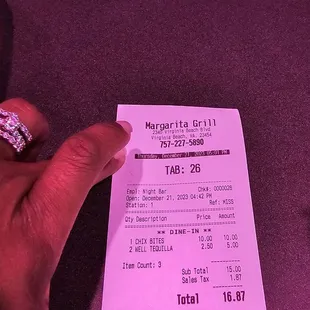 a person&apos;s hand holding a receipt