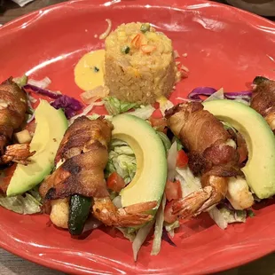 a plate of food with shrimp, avocado, and rice